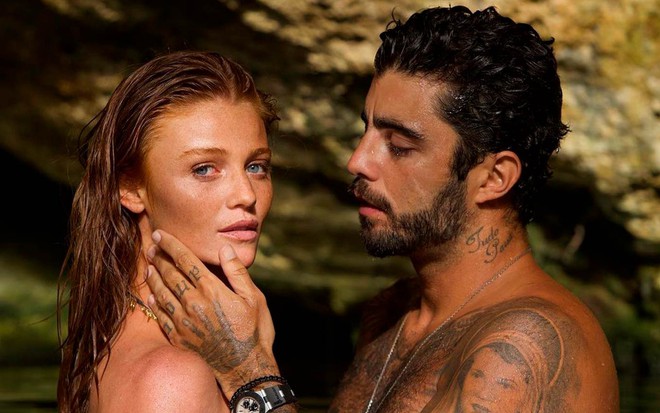 Cinthia Dicker e Pedro Scooby em foto publicada no Instagram: modelo para a câmera enquanto surfista olha para ela e faz carinho em seu rosto