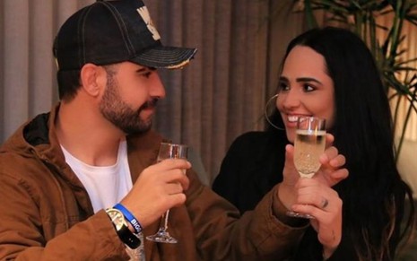 O empresário Diogo Bottino e a cantora Perlla sorriem segurando taças de champanhe em foto publicada no Instagram
