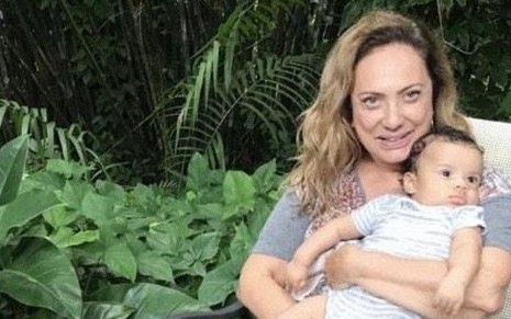 A atriz Eliane Giardini em foto publicada no Instagram em que aparece sentada segurando o bebê Antonio