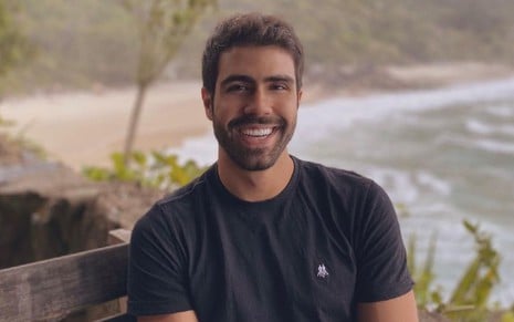 Juliano Laham em foto publicada no Instagram, ator está de camiseta preta e sorri para câmera