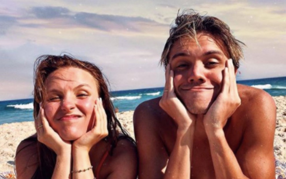 A atriz Larissa Manoela com o namorado, Leo Cidade, em foto publicada no Instagram; eles aparecem deitados de bruços e sorrindo em uma praia