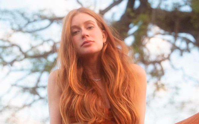 Marina Ruy Barbosa em foto no Instagram: sentada, atriz está com os cabelos soltos e sorri para a câmera