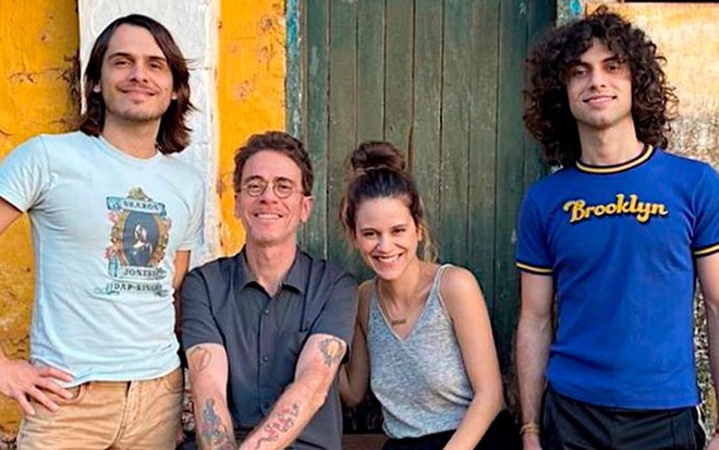 Sentado com a filha Sofia, Nando Reis sorri em foto com os filhos; Sebastião está do lado esquerdo e Theo do lado direito