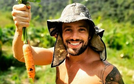 Rafael Cardoso em foto publicada no Instagram: sem camisa, ator usa chapéu e posa com cenoura na mão