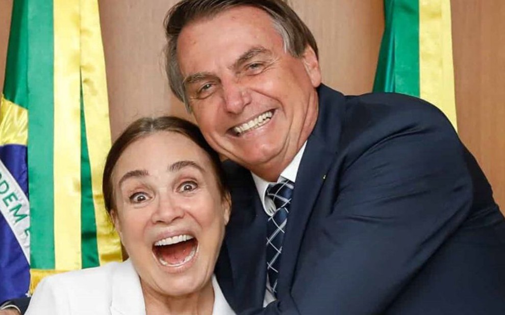 Regina Duarte sorri abraçada com o presidente da República, Jair Bolsonaro