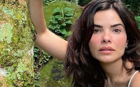 A atriz Vanessa Giácomo em foto publicada no Instagram em que aparece com um fundo de área verde, no meio do mato