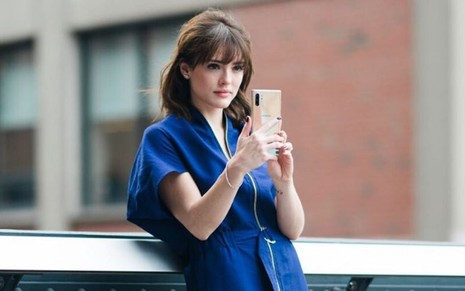 A atriz Isabelle Drummond segura um celular durante ensaio fotográfico nos Estados Unidos 