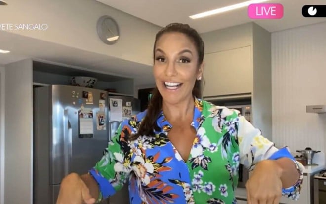 Na cozinha de sua casa, em Salvador, Ivete Sangalo fala sorridente em chamada para live na Globo