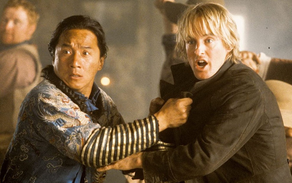 Jackie Chan e Owen Wilson com expressões de susto em cena do filme Bater ou Correr (2000)