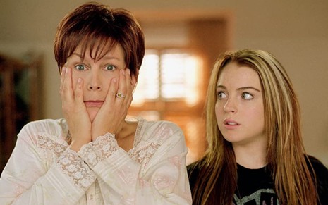 Jamie Lee Curtis com expressão de susto e com as mãos no rosto e Lindsay Lohan olhando para ela
