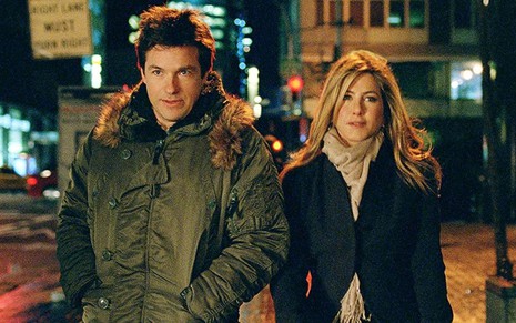 Com roupas de inverno, Jason Bateman e Jennifer Aniston caminham na rua em cena de Coincidências do Amor (2010)