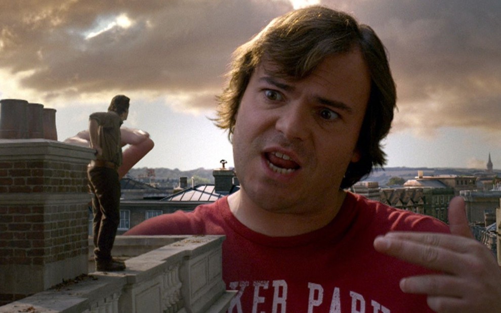 Jason Segel (de costas e bem pequeno) conversa com Jack Black em cena de As Viagens de Gulliver (2010)