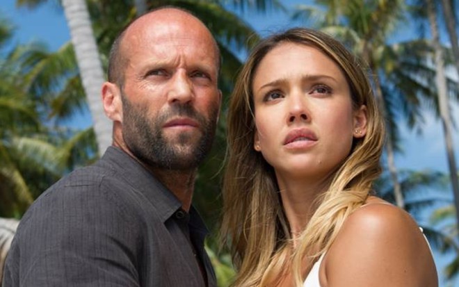 Olhando para frente, Jason Statham segura Jessica Alba pelo braço em cena do filme Assassino a Preço Fixo 2 - A Ressurreição