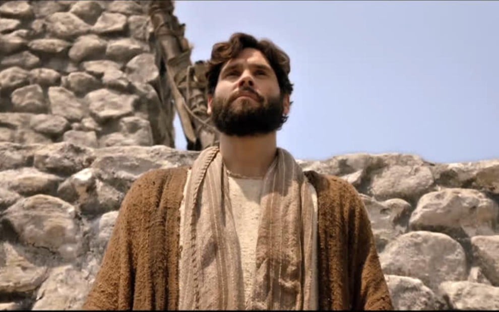 O ator Dudu Azevedo em cena como Jesus, personagem título da novela da Record, com pedras no plano de fundo