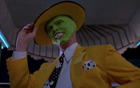 Jim Carrey usa um terno amarelo e chapéu e está caracterizado como a criatura verde de O Máskara (1994)