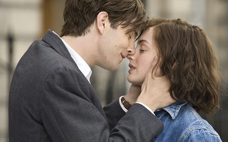 Jim Sturgess segura o rosto de Anne Hathaway e está prestes a beijá-la em cena de Um Dia (2011)