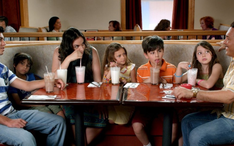 Em uma mesa de lanchonete, estão seis crianças. Na ponta está Ray Ray (Joey Dedio) em cena do filme Tio Papi (2013)