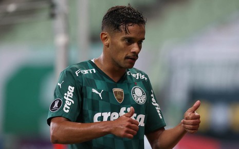Gustavo Scarpa com uniforme verde do Palmeiras virado para a direita e com os dois polegares levantados