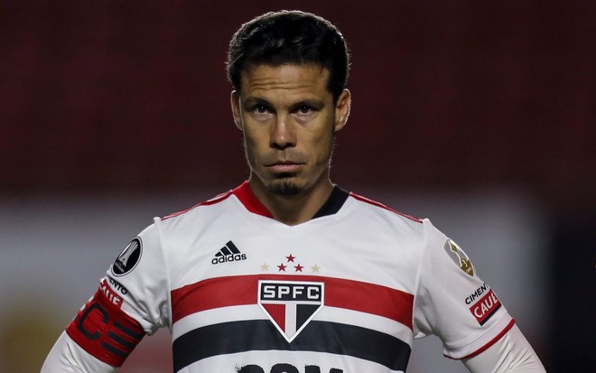 Hernanes com o uniforme branco com detalhes em vermelho e preto do São Paulo e olhar sério