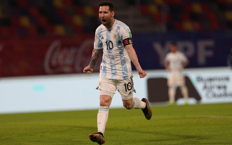 Messi com calção branco e camisa branca e azul da Argentina corre para a esquerda em comemoração
