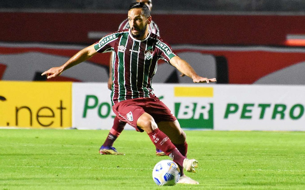 Yago Felipe com camisa verde, vermelha e branca e calção vermelho do Fluminense dominando a bola em jogo