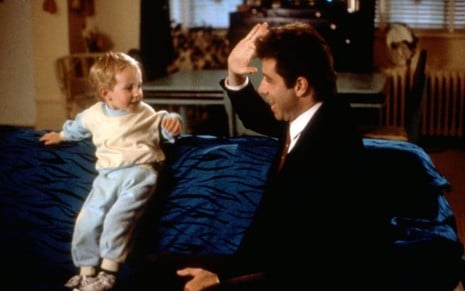 Christopher Aydon e John Travolta brincam em cena de Olha Quem Está Falando (1989)