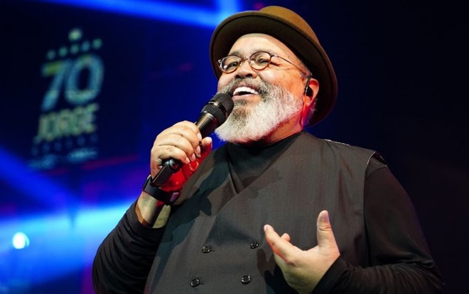 Imagem de Jorge Aragão segurando microfone em show