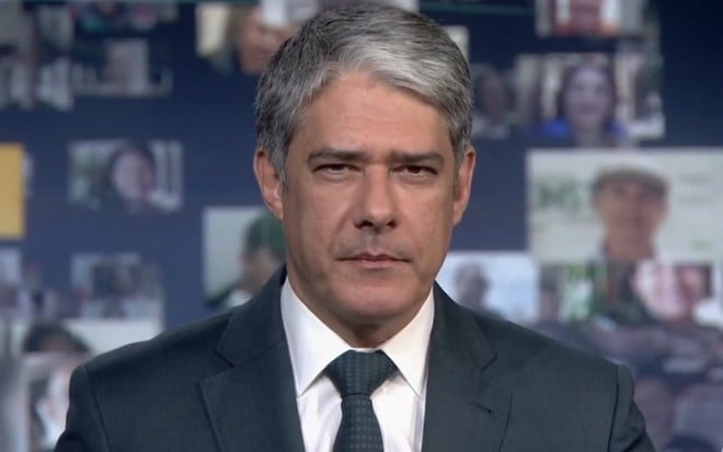 No estúdio do Jornal Nacional, William Bonner olha para a câmera enquanto apresenta o telejornal da Globo