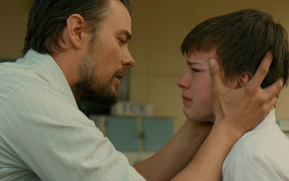 Josh Duhamel segura o rosto do menino Josh Wiggins, que aparece chorando em cena do filme Caminhos Perdidos (2015)