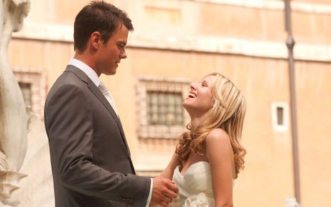 Josh Duhamel olha para Kristen Bell rindo em cena do filme Quando em Roma