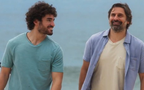Os atores José Condessa e Murilo Rosa caminham sorridentes um ao lado do outro em cena como Juan e Mário de Salve-se Quem Puder
