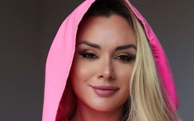 Imagem de Juju Salimeni, com capuz rosa e cabelos loiros