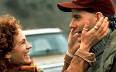 Julia Roberts coloca as mãos no rosto de Campbell Scott em cena de Tudo Por Amor