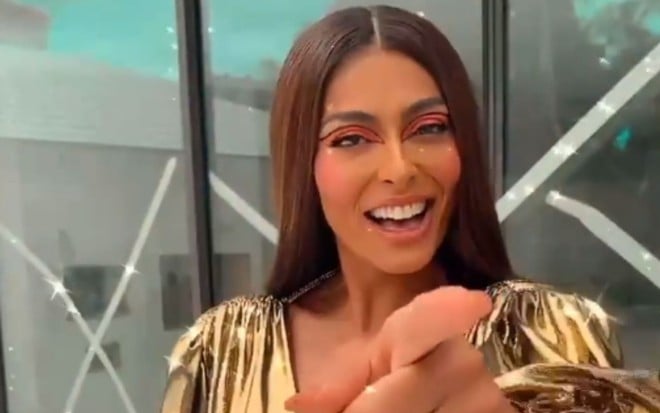 Juliana Paes usa vestido dourado enquanto aponta o dedo para a câmera