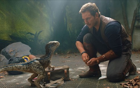 Chris Pratt se comunica com espécie de dinossauro criança em cena de Jurassic World: Reino Ameaçado