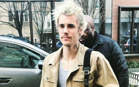 Imagem de Justin Bieber caminhando na rua usando uma jaqueta bege