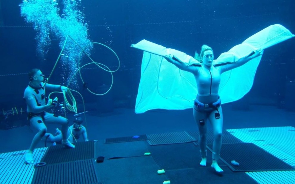 Kate Winslet grava submersa em um tanque com roupas para captura de movimentos em foto dos bastidores de Avatar 2