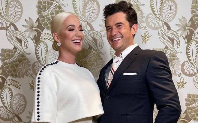 Imagem de Katy Perry, (à esq.) de branco, e Orlando Bloom, de terno, na posse de Joe Biden