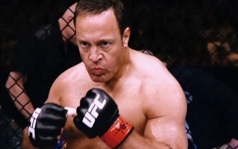 O ator Kevin James sem camisa e com luvas de UFC em cena como Scott Voss, do filme Professor Peso Pesado
