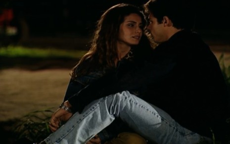 Os atores Giovanna Antonelli e Luigi Baricelli olham um para o outro em cena noturna de Laços de Família