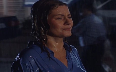 A atriz Vera Fischer com cabelos e roupa molhados, na chuva, com expressão de choro em cena de Laços de Família