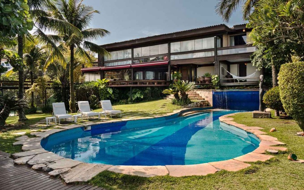 Foto da área externa de mansão no Rio de Janeiro, com bela piscina e área verde