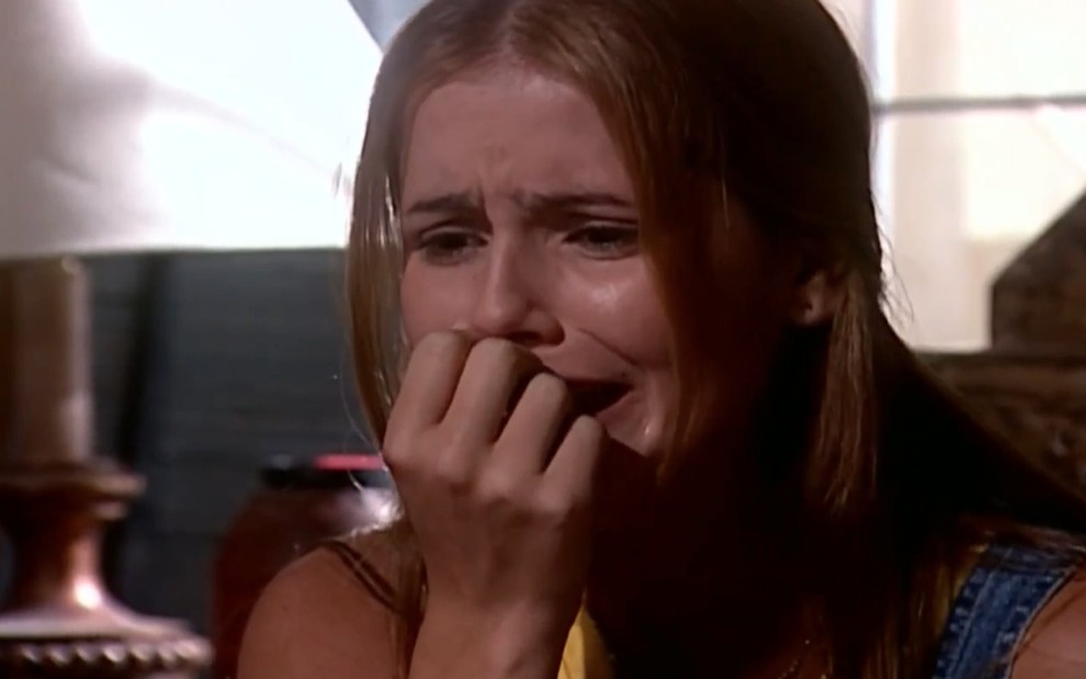 A atriz Deborah Secco chora com mão em frente à boca em cena como Íris de Laços de Família