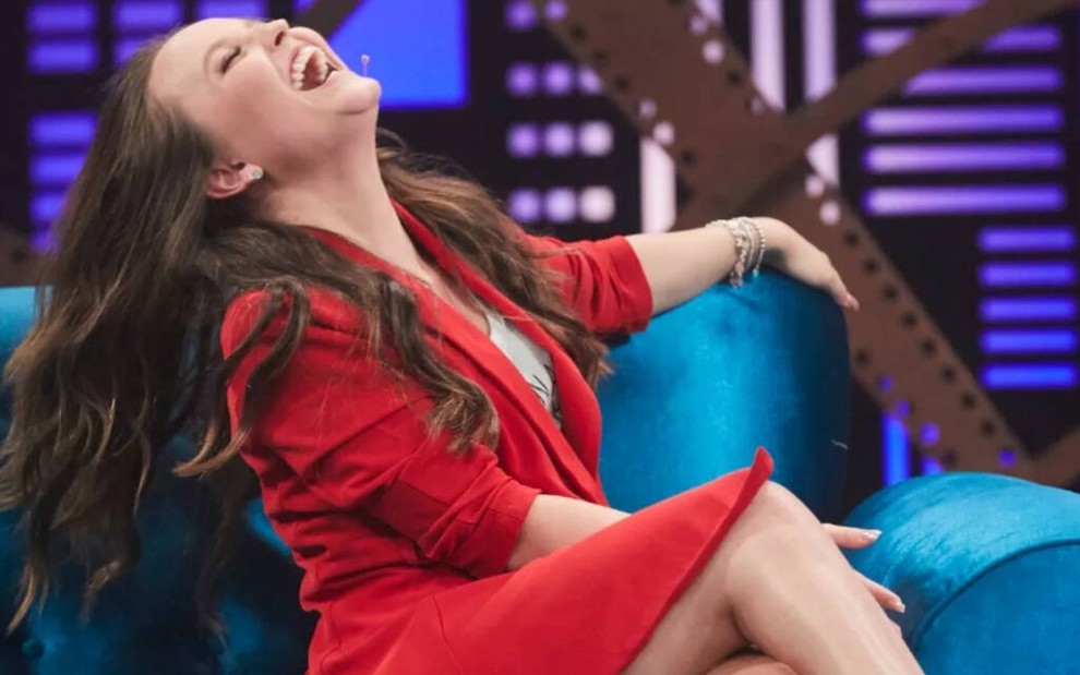 No sofá do programa Lady Night, Larissa Manoela curva o corpo para trás enquanto dá uma gargalhada