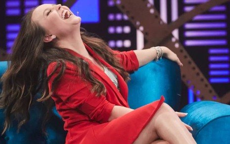 No sofá do programa Lady Night, Larissa Manoela curva o corpo para trás enquanto dá uma gargalhada