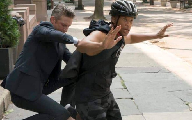 Em uma calçada, Peter Scanavino detém à força Peterson Townsend, ambos ajoelhados em cena de Law & Order: SVU