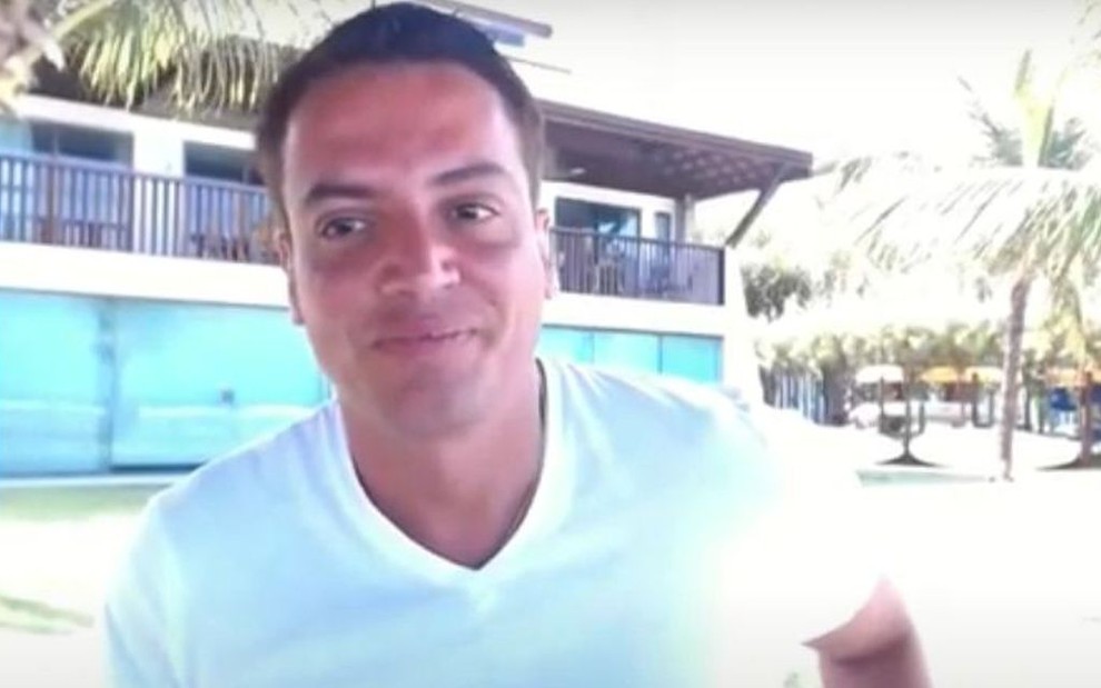 Leo Dias em praia paradisíaca no nordeste, usando camiseta branca e exibindo bronzeado