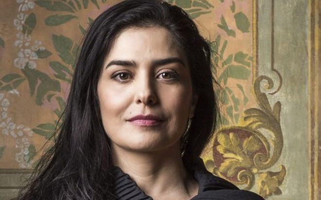Leticia Sabatella de cabelo comprido e liso, com o figurino de Soraia, da novela Órfãos da Terra, da Globo, de 2019