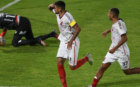 Lucho González coloca a mão na cabeça para comemorar gol do Athletico com Fabinho, que corre ao seu lado
