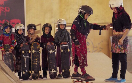 Meninas afegãs com lenços enrolados na cabeça e capacetes fazem aula de skate em cena do documentário Aprendendo a Andar de Skate em Zona de Guerra (Se Você For Menina)